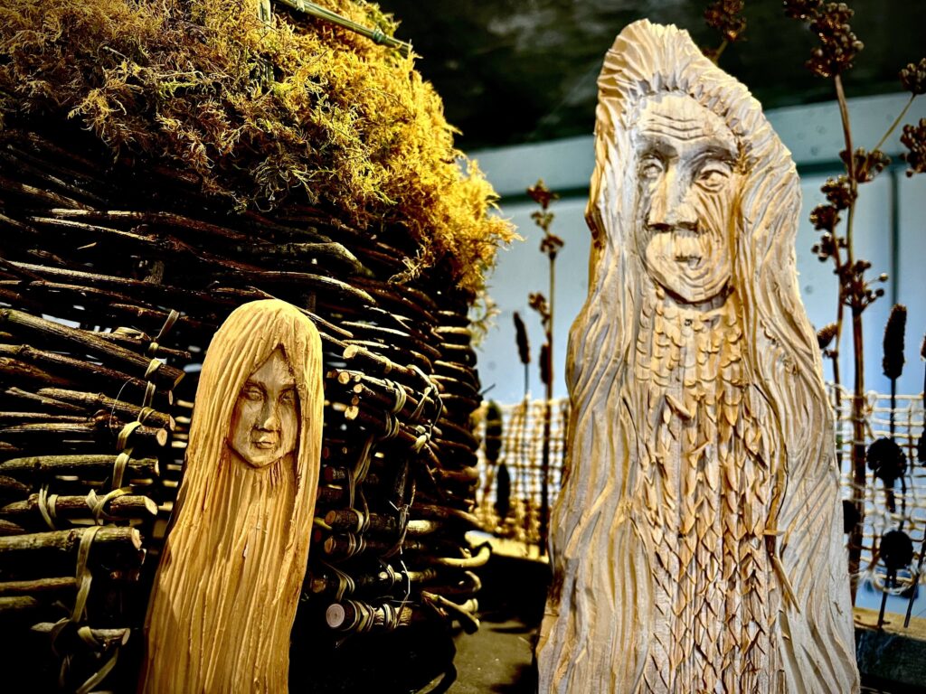Wooden sculptures of a young girl and an old hag